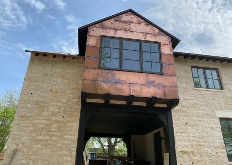 Copper metal panel facade on a stone building for Skylight Installation in St. Francis